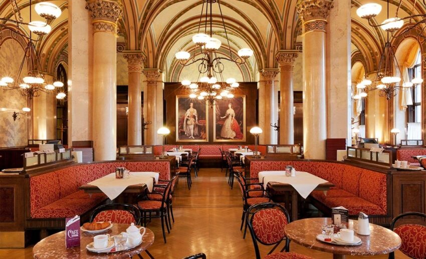 The grand Neo-Gothic vaulted ceilings and elegant pillars inside the historic Café Central in Vienna.